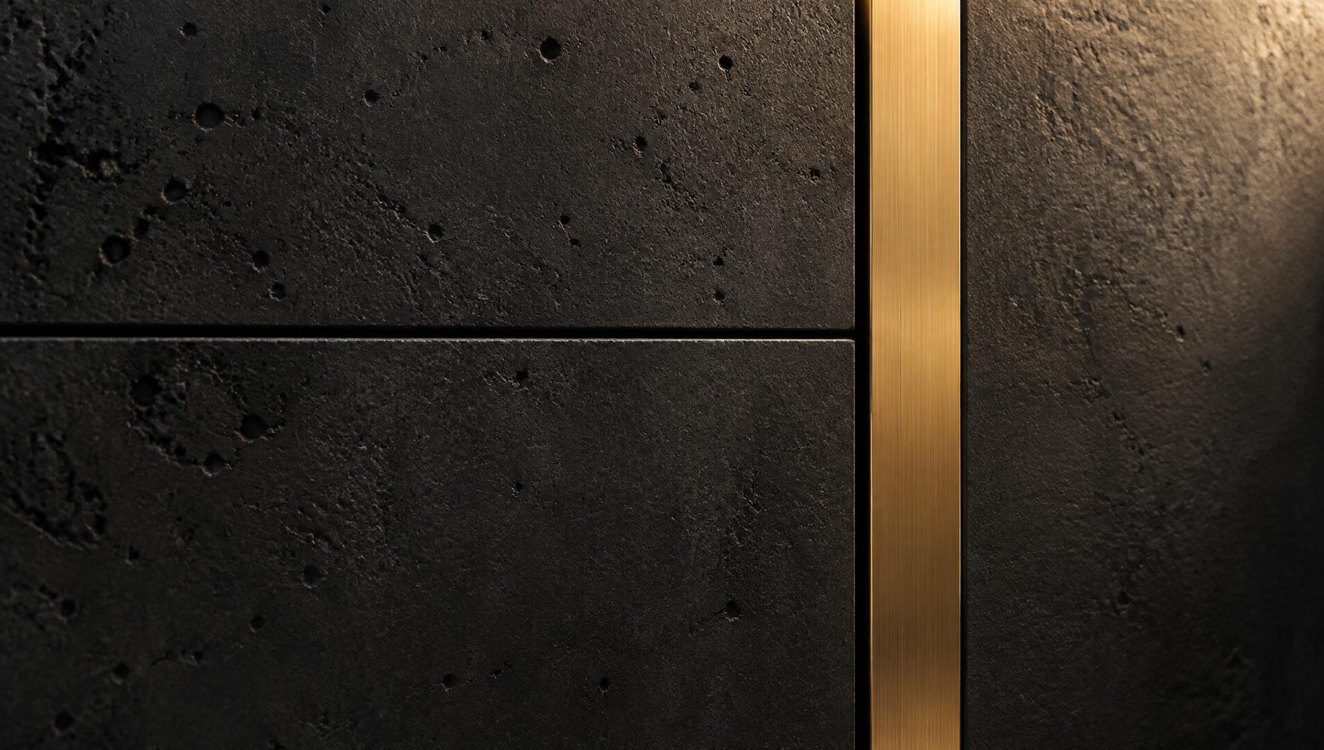 Brushed brass joinery against a textured black concrete wall